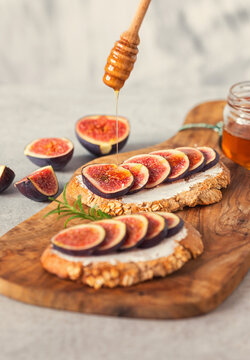 Preparing bruschetta with figs, honey and goat cheese for the breakfast