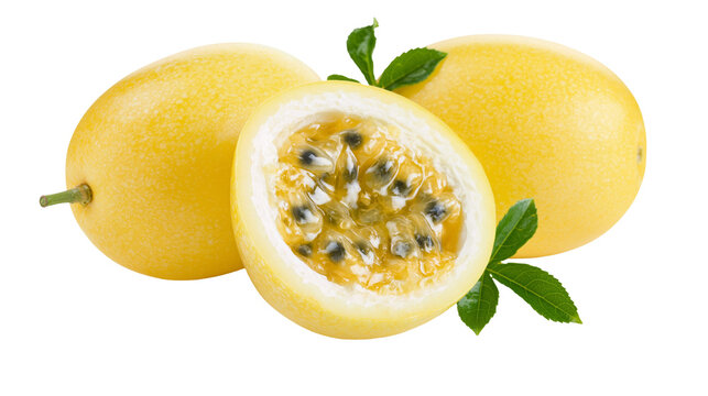 Fresh yellow passion fruit with one halved fruit showing seeds and green leaves