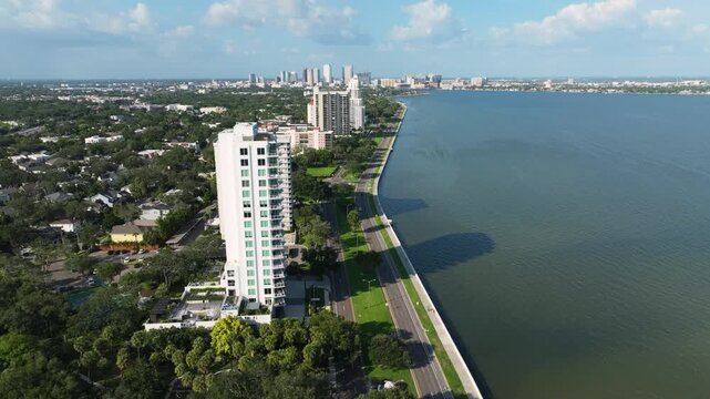 Aerial view of Bayshore Boulevard in Tampa's Hyde Park neighborhood, showcasing upscale condos, the seawall walking path, and the sparkling Hillsborough Bay.