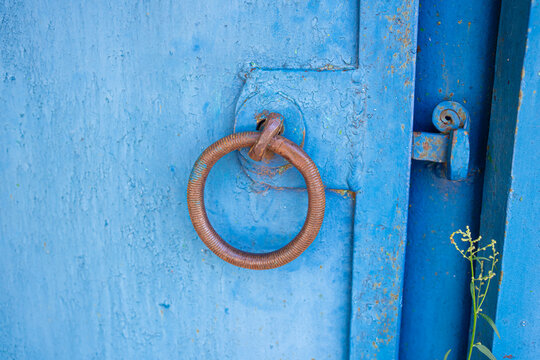 Ring handle on blue iron gate, vintage entrance architecture concept