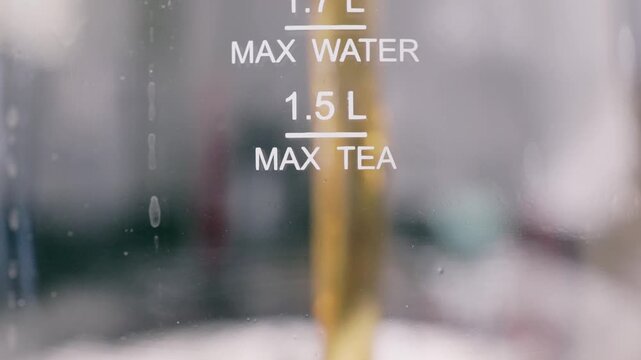 Pouring hot tea into a glass pitcher