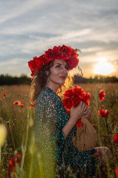 Floral wreath adorns woman holding straw basket in Papaver rhoeas field during sunset golden hour