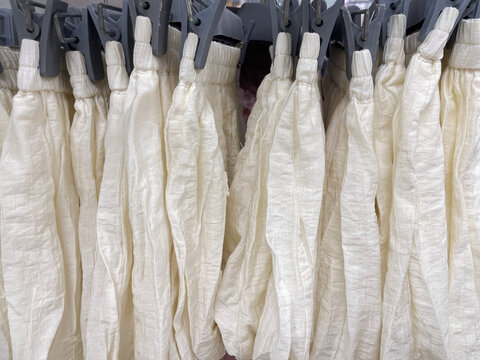 White casual shorts hanging on display, showcasing lightweight clothing with a simple design for everyday fashion and warm-weather wear.