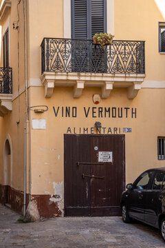 Vintage "Vino Vermouth Alimentari" sign on the facade of an old grocery shop in the historic center of Gallipoli, Salento, Puglia, Italy.