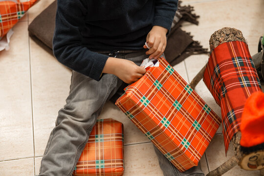 Child opening christmas gift from tio de nadal