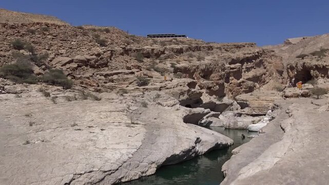 Turquoise pools in a rocky desert canyon at Wadi Bani Khalid, Oman
