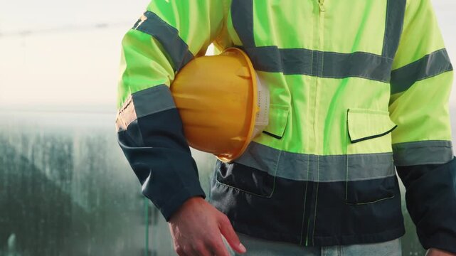 Man, hands and construction worker outdoor with helmet, remodeling project or safety rule compliance. Person, PPE and hard hat on balcony with building site, infrastructure and injury prevention.