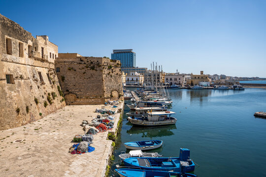 Picturesque fishing boats moored around the historic center of Gallipoli, Salento, Puglia, Italy, a popular travel destination.