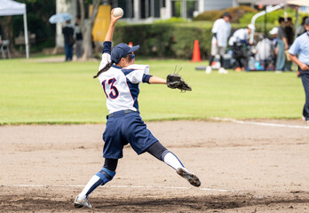 Obraz premium 女子ソフトボールでピッチャーをする女子高生