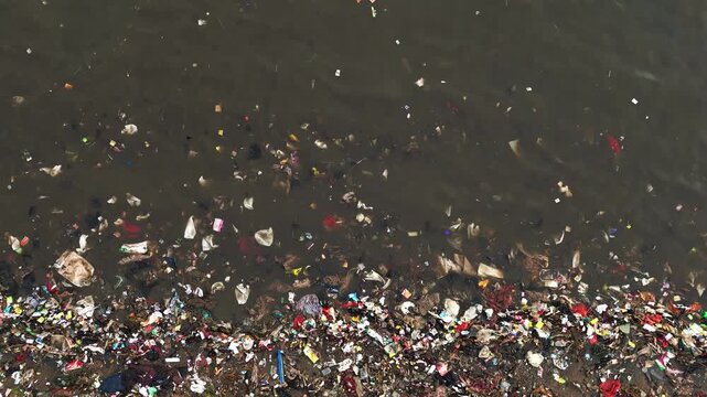 Dynamic aerial drone footage of Lampung shoreline sand darkened by overflowing plastic waste with diverse angles and movements for environmental documentary climate for production design