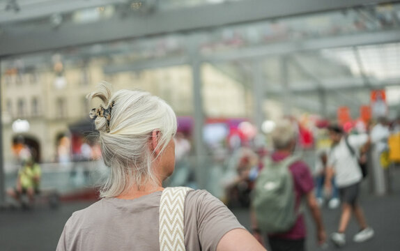 Caucasian senior woman walking at city bus station during evening time - Urban lifestyle concept - UGC content - Main focus on head