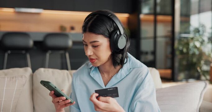 Headphones, phone and woman on sofa with credit card, online shopping and digital banking with music. Happy, home and person on mobile app with audio for payment, transaction and website on weekend