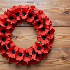 Obraz premium Remembrance day poppy wreath, memorial and peace concept, red flowers for veterans day and armistice commemoration on a rustic wooden background