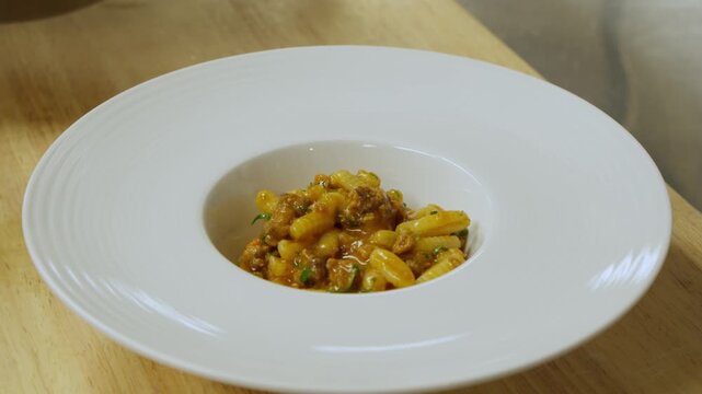 Plating pasta dish in kitchen