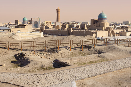 Panoramic view of Bukhara skyline from Ark Fortress ruins showing Kalon Minaret and turquoise domes. Ideal for travel guides, heritage publications, and tourism marketing materials.