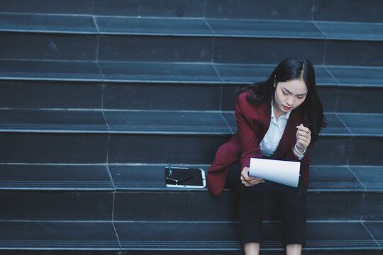 desperate Asian Korean business woman crying alone sitting on street staircase suffering stress and depression crisis being victim of mobbing or fired losing her job