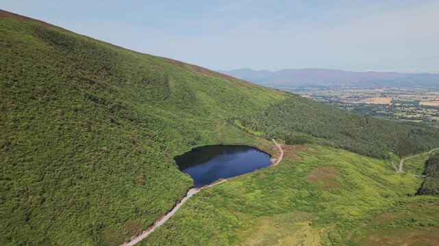 A high angle aerial shot of Bay Lough, a corrie lake nestled in the Knockmealdown Mountains at the Vee Pass, Tipperary, Ireland. Perfect for travel and nature documentaries.