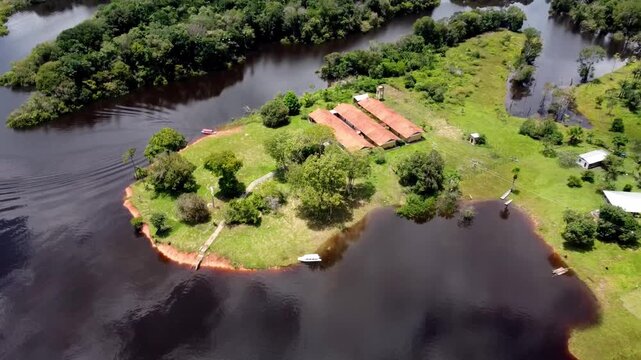 Aerial view of remote lodge located on river island surrounded by lush amazon rainforest vegetation in Brazil.