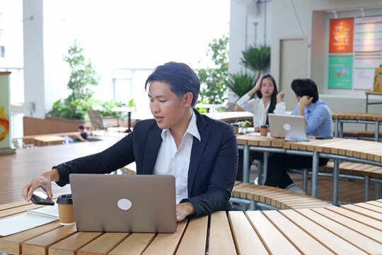 Young Businessman Working on Laptop at Outdoor Coworking Space