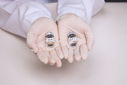 Doctor gloved hand holding vial offers hopeful medical weight management treatment with compassionate care for patient health outcome