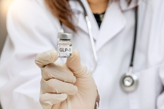 Confident female doctor holding medical vial bottle for weight management treatment to improve patient health with serious care