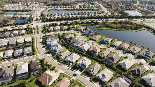 Aerial view of modern suburban residential neighborhood with houses and ponds.