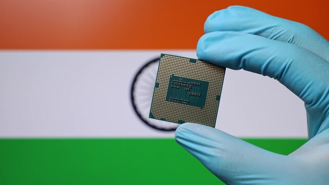 Close up view of hand in blue glove holding CPU microchip. Indian flag in blurred background. Concept of semiconductor shortage and artificial intelligence development in India.
