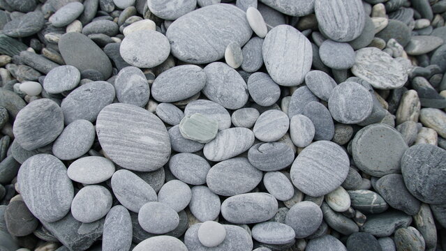 Smooth gray pebbles and stones natural texture background