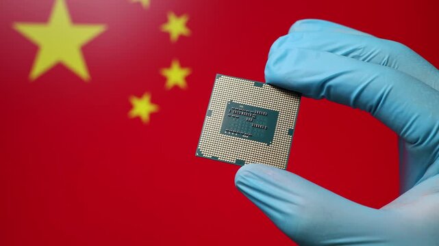 Close up view of hand in blue glove holding CPU microchip. Chinese flag in blurred background. Concept of semiconductor shortage and artificial intelligence development in China.