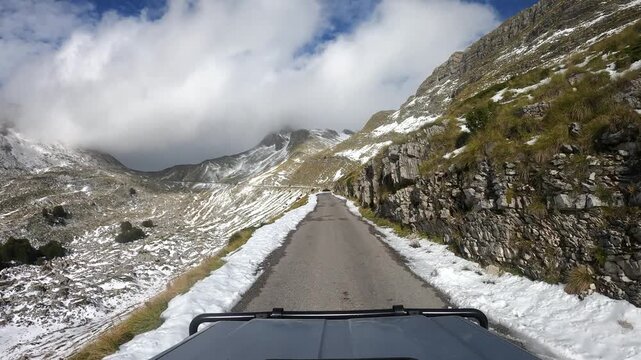 POV driving up a snowy road to Sedlo Pass in Durmitor National Park rural Montenegro