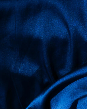 Vertical dark blue textured satin background with subtle grain effect and copy space