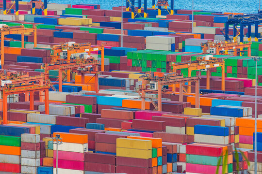 Extensive container stacks beneath cargo cranes at Shenzhen Port. Freight logistics, international shipping, container transportation and global trade operations