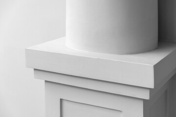 Naklejka premium Close-up of a white architectural column base and pedestal showcasing clean lines, subtle texture and minimalist classical design. Neutral tones emphasize shape, geometry and architectural details