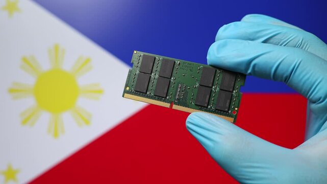 Close up view of hand in blue glove holding RAM memory microchip module. Filipino flag in blurred background. Concept of semiconductor shortage and artificial intelligence development in Philippines.