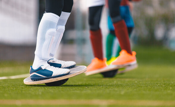 Close-Up Side Profile of Athlete Performing Balance Board Stability Exercises on Grass - Youth Sports Proprioception and Ankle Rehabilitation Drill