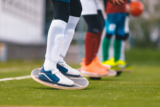 Young Athlete Balancing on Wobble Board on Turf Pitch - Junior Soccer Propriocetion and Core Stability Balance Training Session