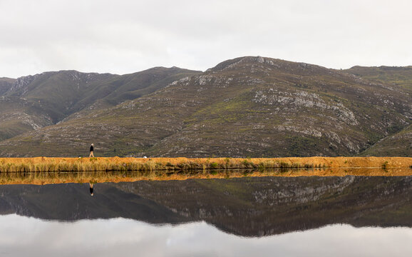 man walking perimeter of pond at dawn, Stanford, South Africa
