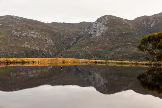 man walking perimeter of pond at dawn, Stanford, South Africa
