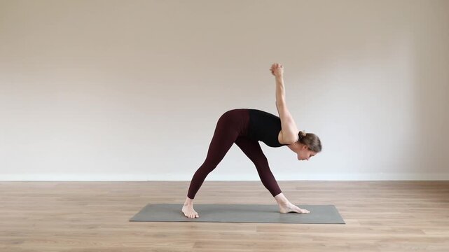Woman practicing yoga in a modern yoga studio, focusing on balance, flexibility, mindfulness and relaxation in a peaceful wellness environment.