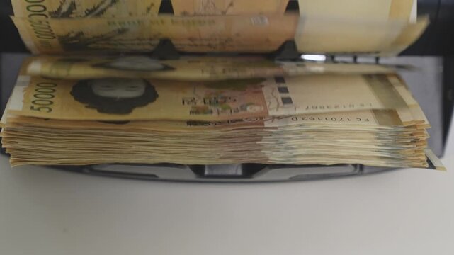 Close-up Fixed Shot of Money Counting Machine Counting 100 Crisp 50,000 Won Banknotes (Cash, Banking, Finance)