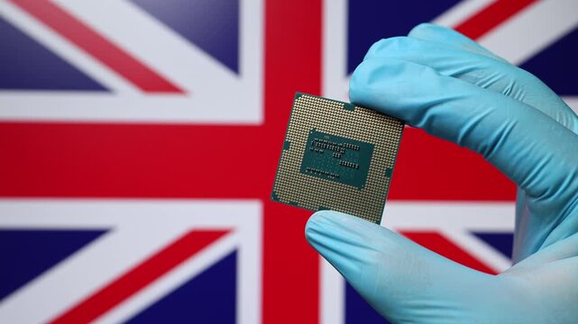 Close up view of hand in blue glove holding CPU microchip. British flag in blurred background. Concept of semiconductor shortage and artificial intelligence development in United Kingdom.