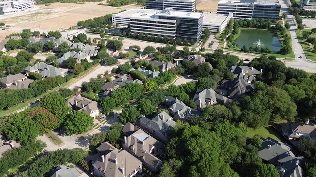 Curved suburban drives cross Stonebriar Creek Estates bordering Internet Boulevard. Multi-story Hall Park offices rise beyond private residential tree lines near Warren Parkway, Frisco, Texas