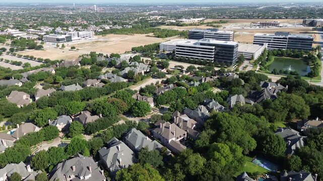 Wooded cul-de-sacs traverse Stonebriar Creek Estates facing Warren Parkway office campuses. Modern business headquarters overlook suburban rooflines near Internet Boulevard, Frisco, Texas
