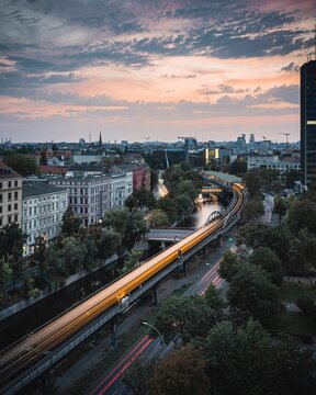 Elevated Yellow Train Motion Blur Above River Canal in Berlin Cityscape at Dusk