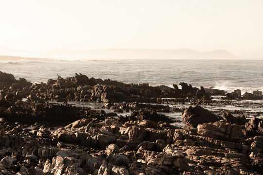 sunrise over waves and rocky coastline, Onrus Beach, Onrus, South Africa