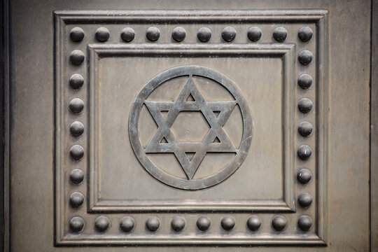 Ornamental metalwork with hexagram motif, geometric symmetry, decorative panel, vintage craftsmanship, architectural detail and sacred design.