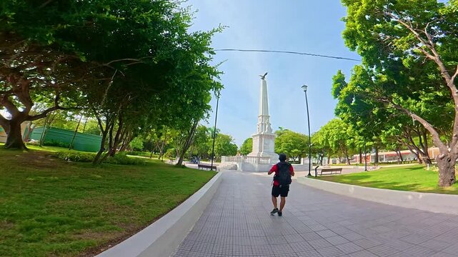 Male tourist walking towards camellon de los martires monument in cartagena