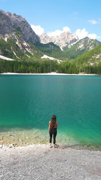 Vertical View of Woman Walking on Lakeside of Lago di Braies, Scanic Lake and Tourist Attraction of Italian Dolomites