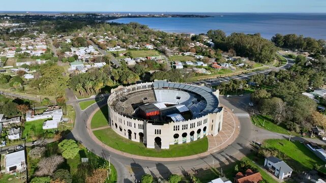 Plaza de Toros Real de San Carlos revealing the waterfront neighborhood in Colonia del Sacramento, Uruguay with aerial orbit counterclockwise.