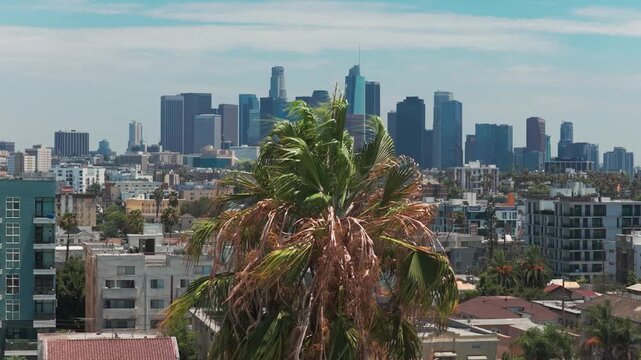 Rising telephoto aerial shot of the downtown skyline from Koreatown in Los Angeles, California. 4K